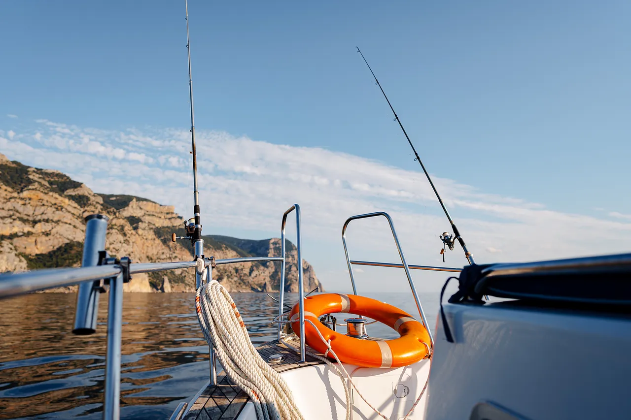 Salvavidas y cañas de pesca en la popa de un barco